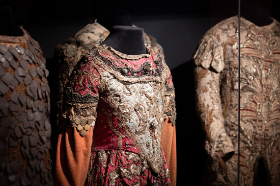Detailaufnahme historischer Theaterkostüme in der großen Vitrine der Theaterräume.