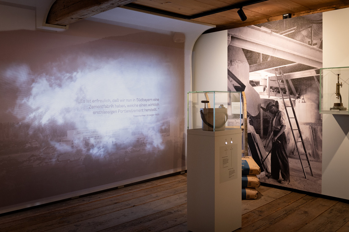 Rauchwolken in einer Projektion vernebeln das Ortsbild in der Ausstellung. Foto: Linus Rapp
