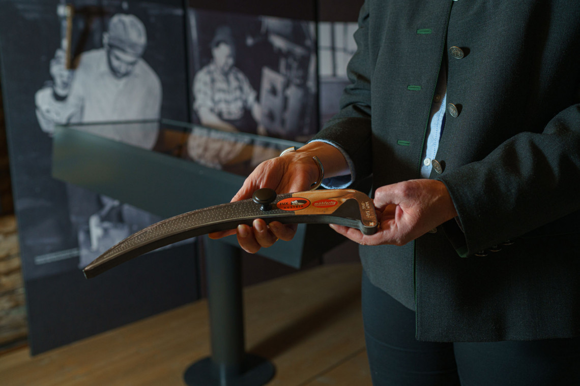 Eine Frau hält eine Miniatursense der interaktiven Station „Sensenmemory“ im Sensenraum